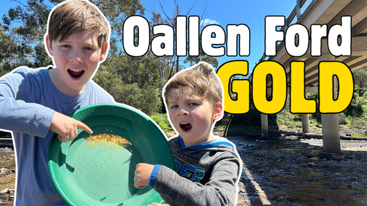 Oallen Ford Gold. Two young boys standing under the bridge in the creek holding a pan of gold